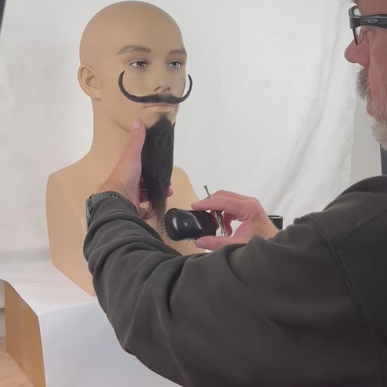 Video of a fake beard being styled and trimmed.