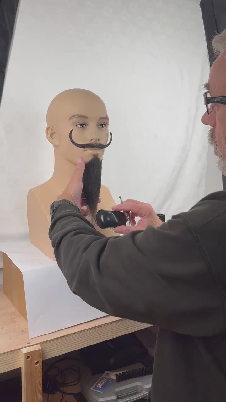 Video of a fake beard being styled and trimmed.